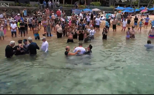 Greg Laurie batiza membros da Capela Kumulani, em Maui. (Captura de tela/CBN News)