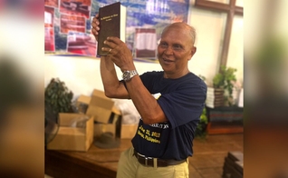 Nard Pugyao segurando a Bíblia no idioma Isnag. (Foto: Wycliffe Bible Translators)