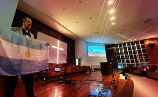 Líder cristão segura a bandeira argentina. (Foto: Facebook/Alianza Cristiana de Iglesias Evangélicas de la República Argentina)