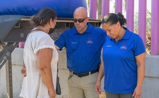 Os capelães Steven e Annmarie orando por uma mulher. (Foto: Reprodução/Billy Graham Evangelistic Association)