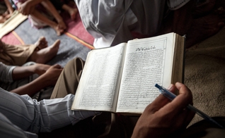 Um cristão paquistanês lê sua Bíblia durante um culto de domingo de manhã na igreja de uma comunidade ocupada. (Foto: IMB)
