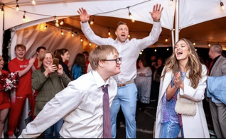 Participantes do evento Noite para Brilhar e Tim Tebow ao fundo. (Foto: X/Tim Tebow)