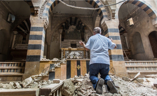 Cristão ora de joelhos em igreja destruída. (Foto: TBAW)