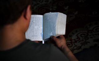 Abdulla lendo uma Bíblia em língua farsi. (Foto: Portas Abertas)