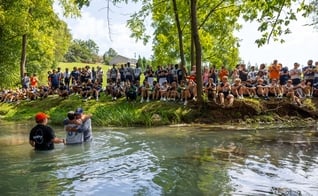 O batismo foi realizado em um riacho. (Foto: X/Carson-Newman University).