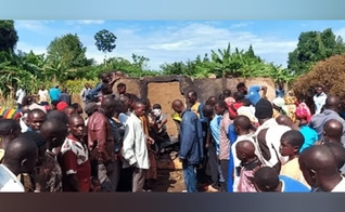 Moradores reunidos em frente à casa queimada do pastor Mukisa. (Foto: Morning Star News).