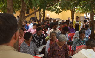 Cambojanos ouvem pregação da Palavra de Deus em terreno budista. (Captura de tela/Cambodia Christian Ministries)