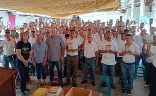 Os presidiários com as Bíblias na prisão. (Foto: Reprodução/Mission Cry)