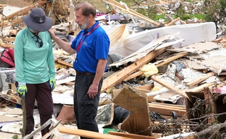 Um capelão orando com uma mulher que perdeu tudo após um tornado. (Foto: Reprodução/BGEA)