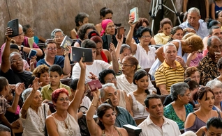 Evangélicos de uma igreja cubana erguem suas Bíblias durante o culto. (Foto: IMB)