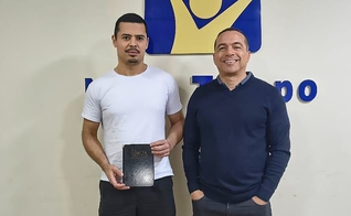 Jadesson e Willyan com a Bíblia perdida. (Foto: Reprodução/Notícias Adventistas)