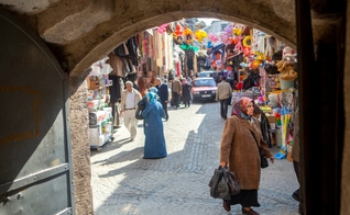Homens e mulheres caminham por um mercado que vende roupas, alimentos e artigos para o lar em um bairro de Istambul, Turquia. (Foto: IMB)