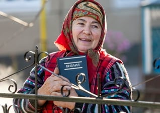 Uma mulher segura uma Bíblia em russo que lhe foi dada por missionários da IMB. (Foto ilustrativa: IMB).