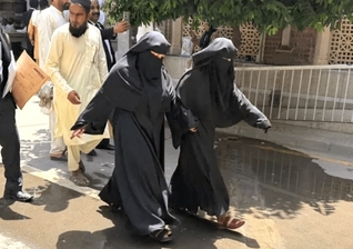 Neha Faqir (à direita) em traje islâmico a caminho do tribunal em Lahore. (Foto: CSI).