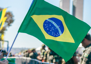 Bandeira do Brasil é erguida durante manifestação popular. (Foto: Pexels)