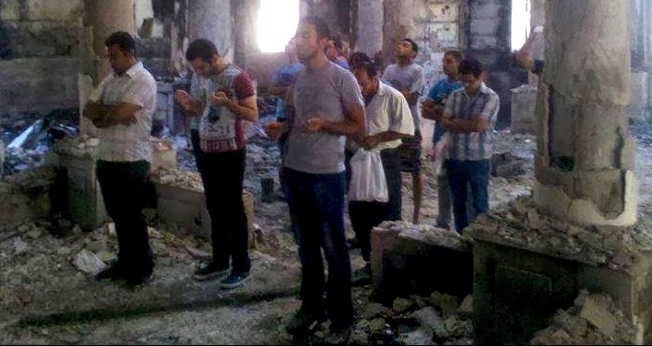Cristãos oram dentro de templo em ruínas, na Síria.