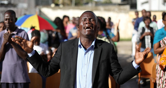 Cristãos durante culto depois que sua igreja foi destruída pelo ciclone Idai, em Moçambique. (Foto: Reuters/Siphiwe Sibeko)