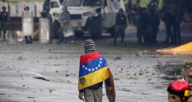 Manifestante de frente para as Forças Armadas em protesto contra Nicolás Maduro, na Venezuela. (Foto: Reuters/Carlos Garcia Rawlins)
