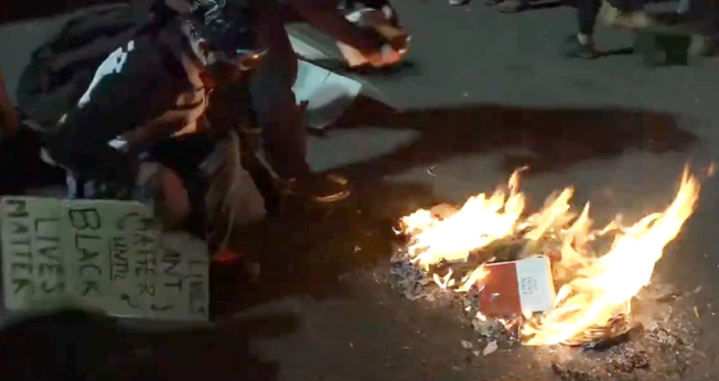 Manifestantes queimam Bíblia em protesto na cidade de Portland, EUA. (Foto: Reprodução/YouTube)