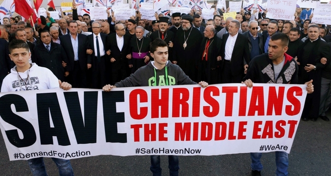 Cristãos assírios participam de protesto contra a perseguição religiosa e pedem pela libertação dos reféns, mantidos pelo Estado Islâmico (Foto: Reuters)