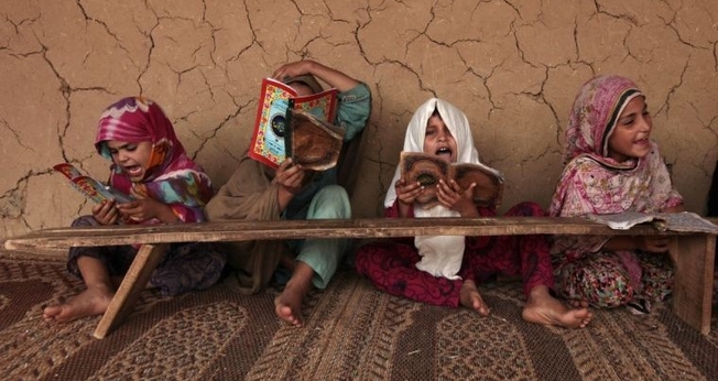 Garotas paquistanesas leem livros com versos do Corão em uma 'Madrasa' ou escola religiosa. (Foto: Reuters)
