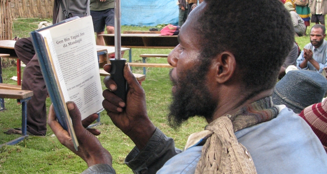 Morador de Papua Nova Guiné lê a Bíblia. (Foto: Joy Ellen)