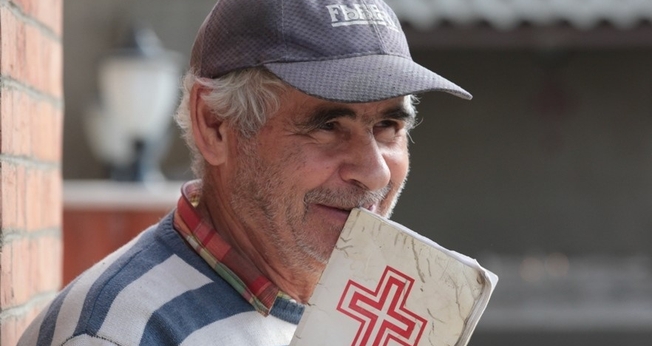 Cristão iraniano segura Bíblia nas mãos. (Foto: Sat 7)