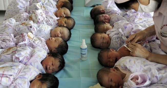 Bebês são cuidados por enfermeira na China. (Foto: South China Morning Post)