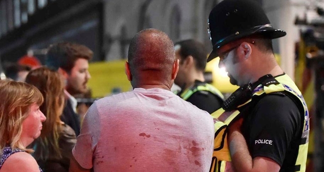 Feridos pelo ataque são atendidos por policial em Londres. (Foto: Reuters)