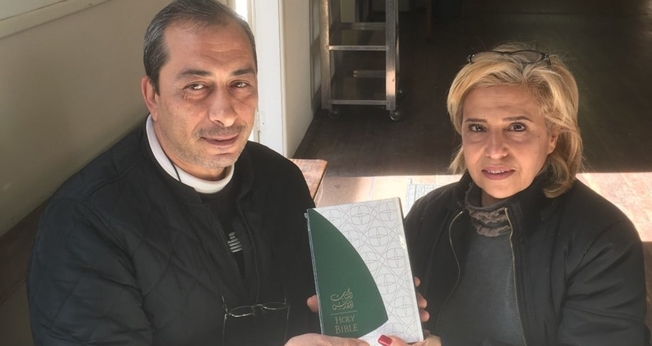 Rafi (esqueda) e Fadia (direita) segurando sua nova Bíblia que ganharam na Austrália. (Foto: Eternity News)