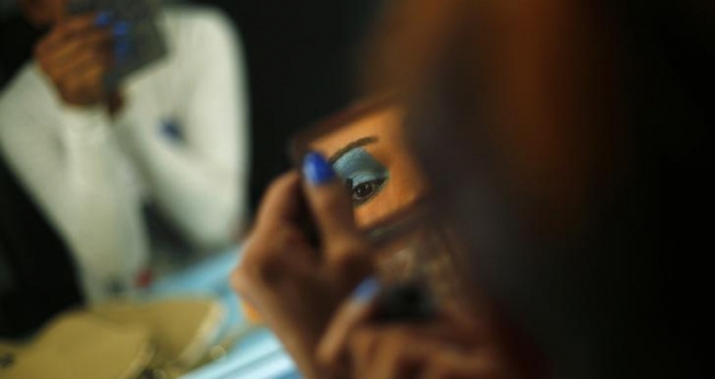 Modelo transexual se maquia antes de se apresentar em Nova Deli, na Índia. (Foto: Reuters/Adnan Abidi)