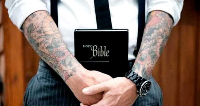 Braços tatuados seguram Bíblia. (Foto: cinconoticias.com)