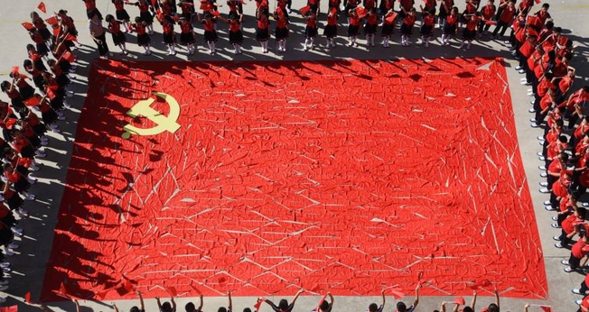 Estudantes ao redor de uma bandeira do Partido Comunista Chinês, na província de Shandong. (Foto: Reuters)
