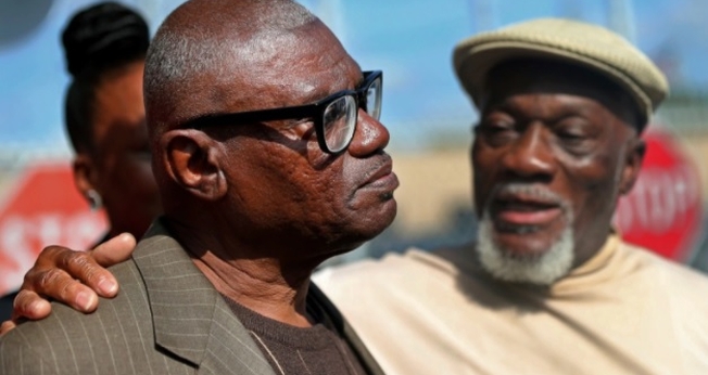 Wilbert Jones falando aos repórteres após deixar a prisão ao lado de seu irmão, Plem Jones. (Foto: Gerald Herbert/Associated Press)