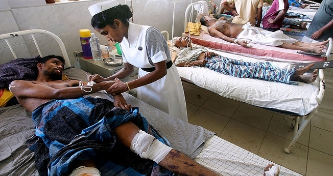 Imagem ilustrativa. Enfermeira cuida de homem enfermo em hospital, na Índia. (Foto: Reprodução)