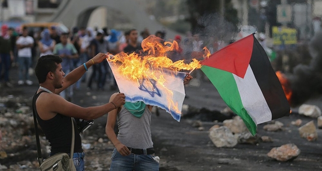 Palestino queima bandeira de Israel em protesto. (Foto: Sputnik International)