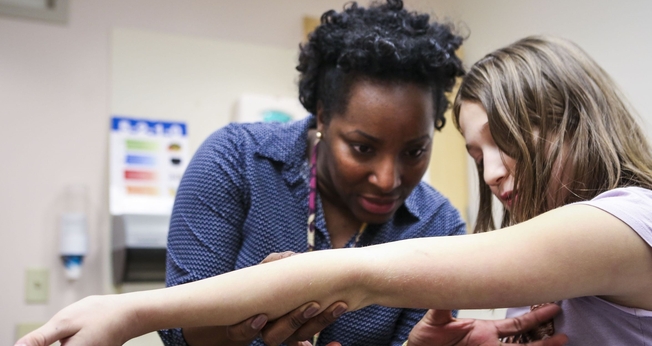 Médica analisa braço de criança na clínica transgênero de Cincinatti, nos Estados Unidos. (Foto: Cincinnati Enquirer)
