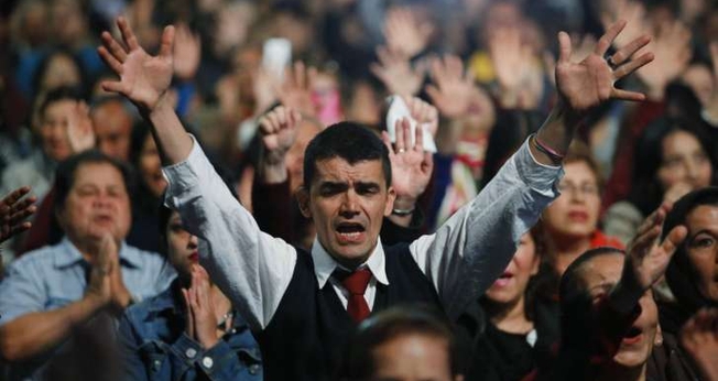 Pessoas orando durante culto evangélico em Bogotá, na Colômbia. (Foto: AP Photo/Fernando Vergara)
