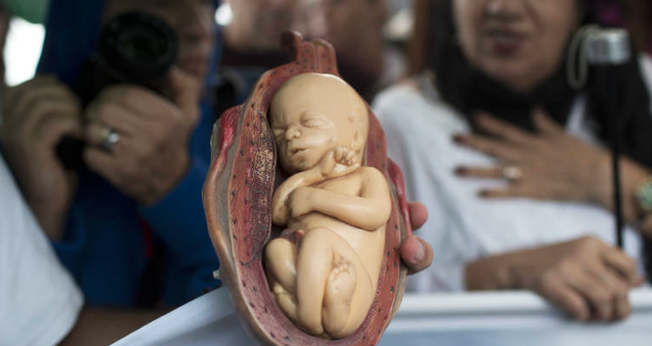 Feto feito de plástico em evento católico contra a legalização do aborto, no Rio de Janeiro. (Foto: Silvia Izquierdo/Associated Press)