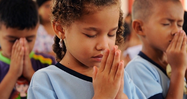 Crianças participam de momento de oração em escola. (Foto: Compassion)