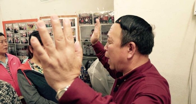 Pastor de igreja doméstica lidera momento de oração, na China. (Foto: ABC News)