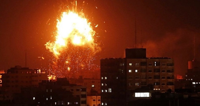 Bola de fogo sobre o prédio que abriga a TV Al-Aqsa, controlada pelo Hamas, na Faixa de Gaza. (Foto: Mahmud Hams/AFP)
