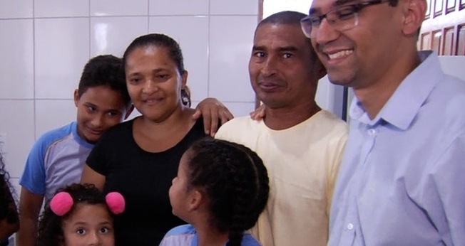 Ao lado dos filhos e do diretor da escola, casal se emocionou com nova casa. (Foto: Reprodução/TV Anhanguera)
