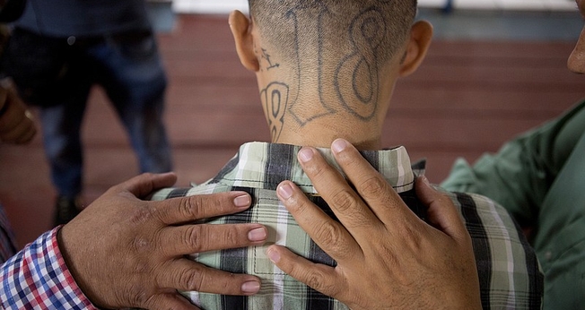 José Rolando Arévalo, 24 anos, ex-membro de uma gangue, recebe oração de pastores. (Foto: Alicia Vera)