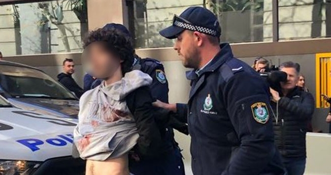 Homem gritou 'Alá é grande' depois de atingir uma mulher com a faca e foi contido por civis na rua, antes de ser preso. (Foto: 10 Daily News)