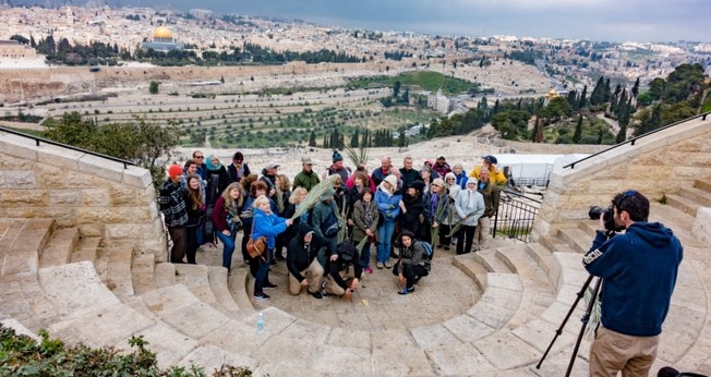 Grupo de turistas tira foto no Monte das Oliveiras, com a cidade velha de Jerusalém em segundo plano. (Foto: Shutterstock)
