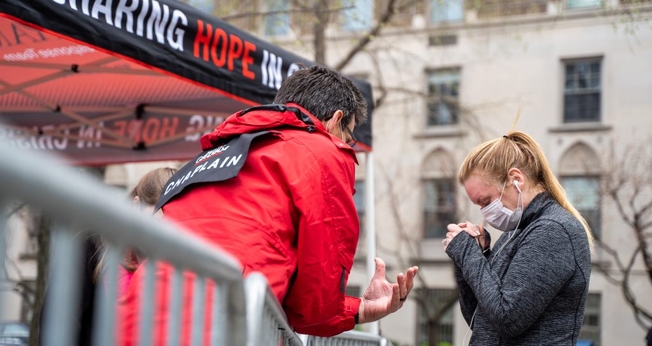 Capelão Charlie Clark ora pela moradora de Nova York, Jennifer Armitage, em frente à tenda de oração. (Foto: Billy Graham Evangelistic Association)