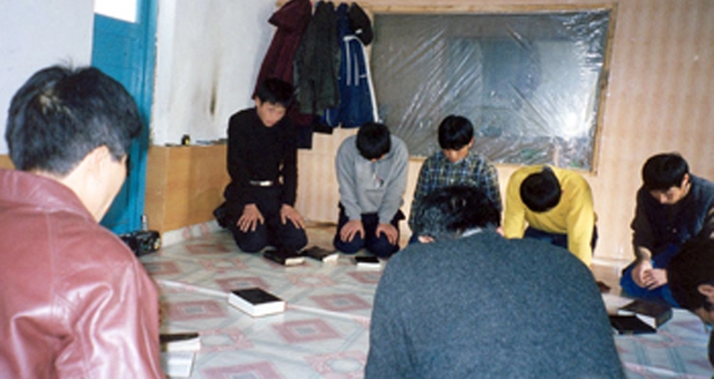 Cristãos oram ajoelhados em igreja clandestina da Coreia do Norte. (Foto: GodReports)