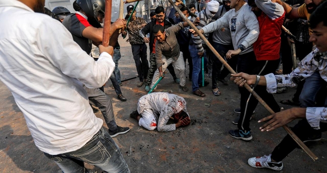 Grupo de hindus espancam homem durante protestos em Nova Délhi, na Índia. (Foto: Reuters/Danish Siddiqui)