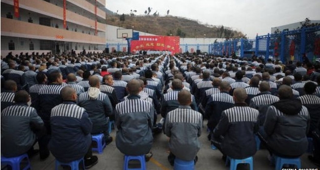 Prisioneiros na China assistem a programações que visam sua doutrinação ao sistema comunista. (Foto: BBC)